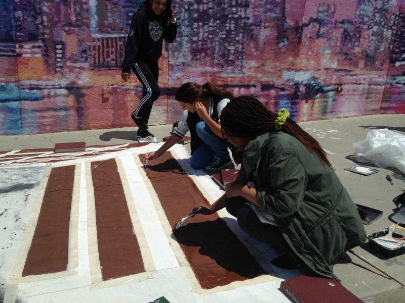 Sophie Mbela, Gabby Mohun, and Jennifer Quijada paint the backdrop for the Last Supper.